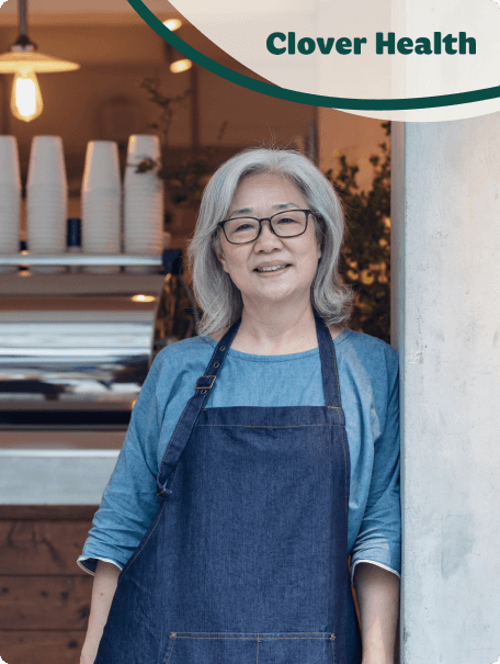 Senior woman smiling at cafe with Clover Health logo