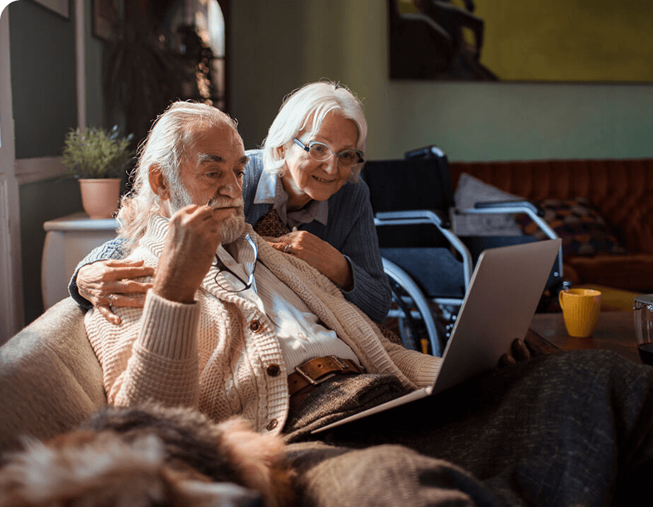 Senior couple on the couch looking at computer