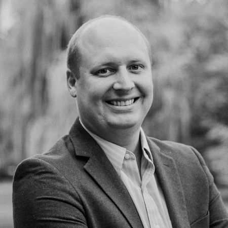 Black and white image of Brad Diephuis smiling with a blurred background.